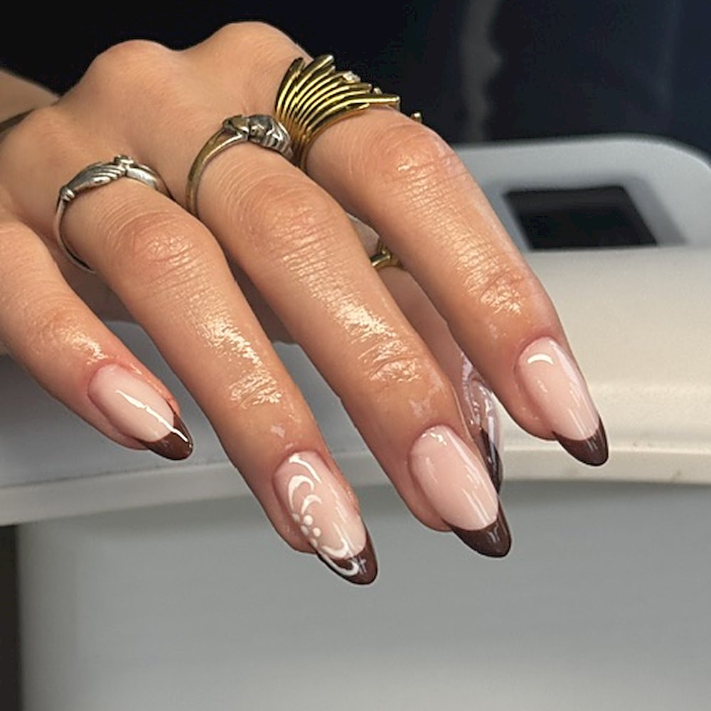 Lange amandelvormige nagels met een chocoladebruine french en fijne witte lijnen
